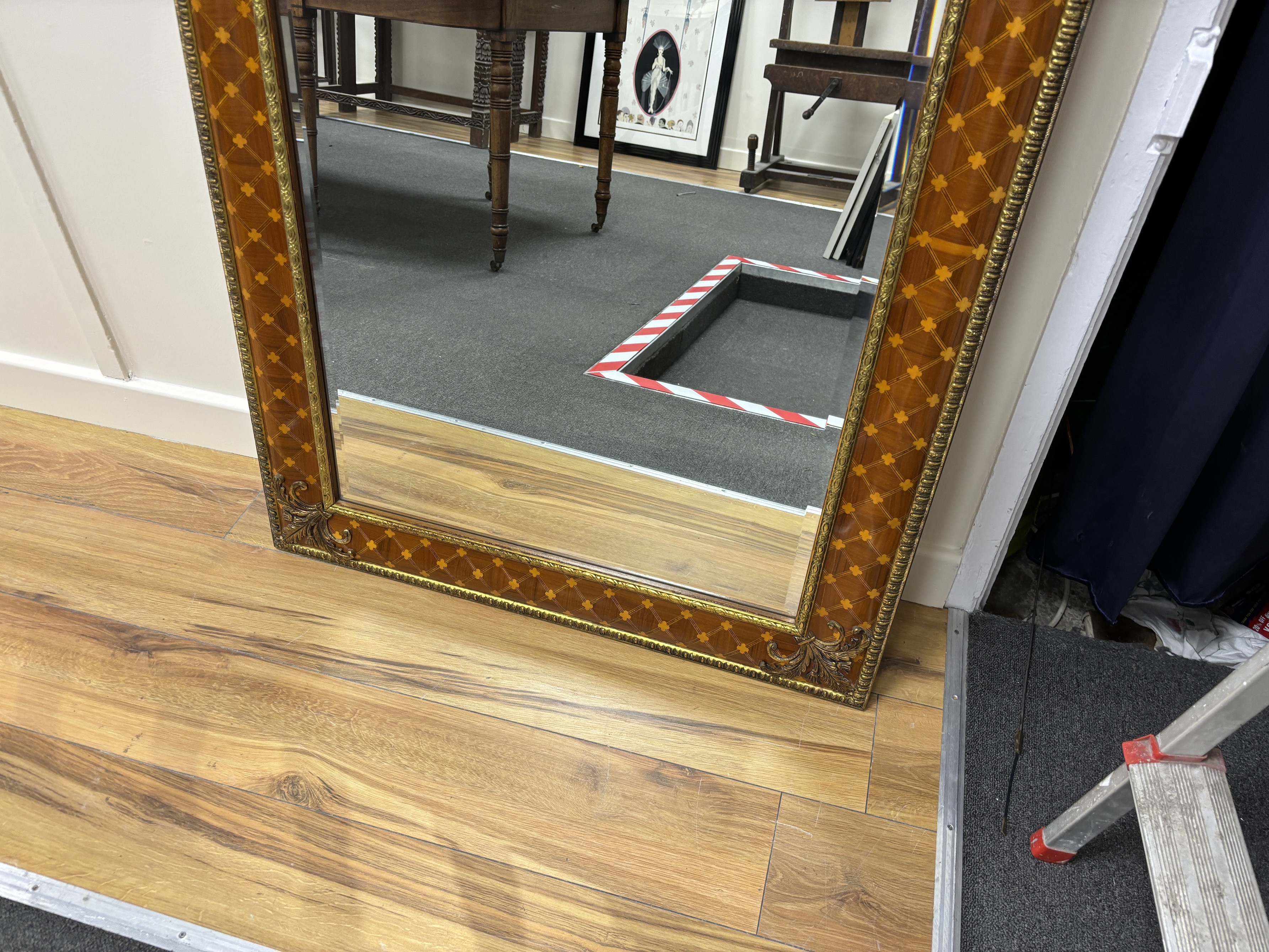 A bevelled wall mirror, the inlaid frame with trellis pattern and gilt metal mounts (purchased from Harrods), width 99cm, height 80cm